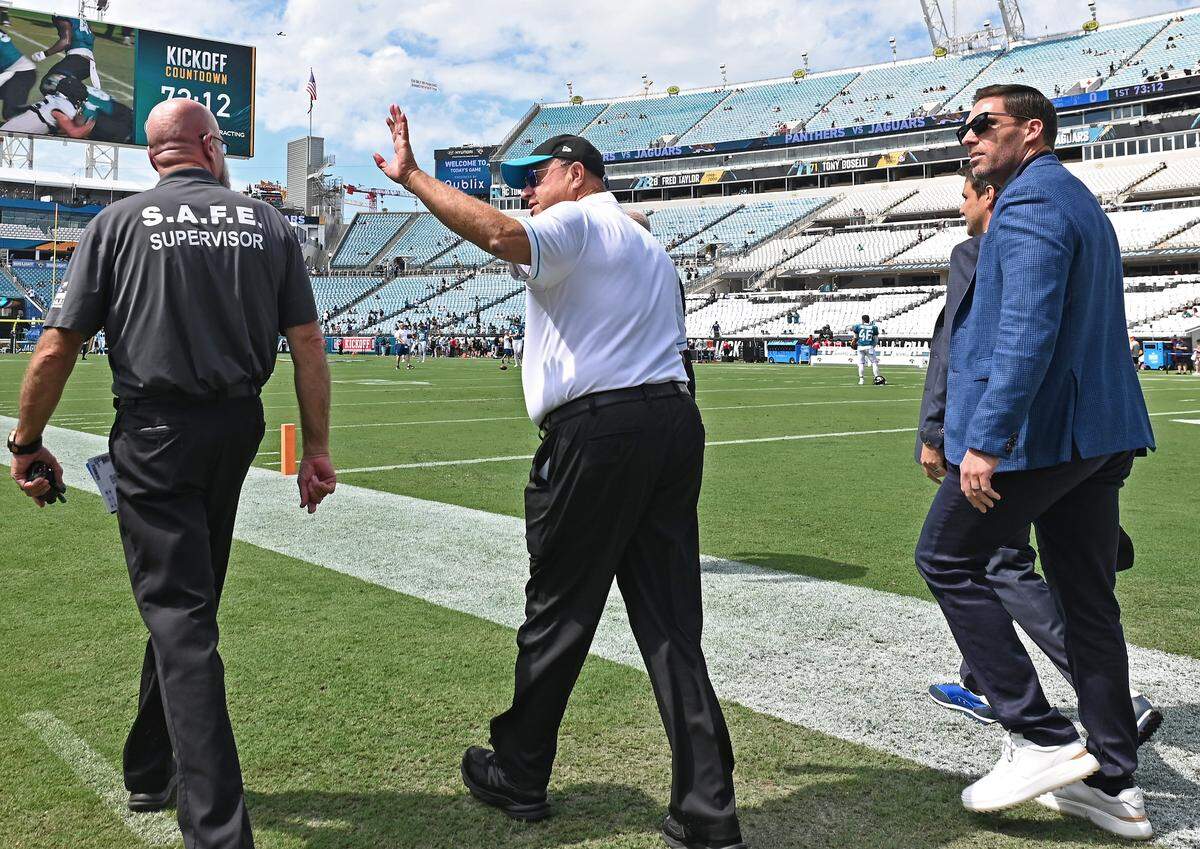 Carolina Panthers team owner David Tepper, center, waves to cheering fans as he and general manager Dan Morgan, right, walk onto the field prior to their game against the Jacksonville Jaguars on Sunday, September 7, 2025 at Everbank Stadium in Jacksonville, Florida.