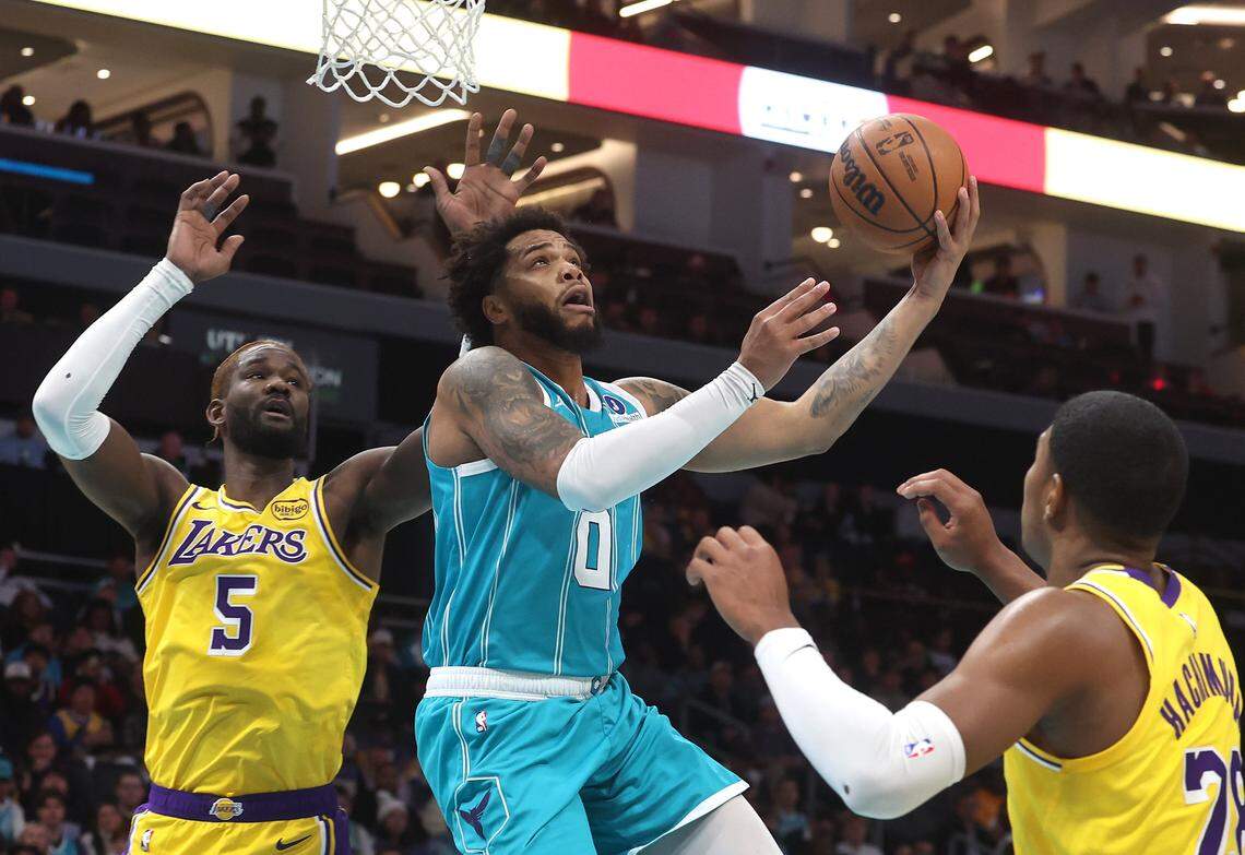 Charlotte Hornets forward Miles Bridges, center, splits Los Angeles Lakers defenders center Deandre Ayton, left and forward Rui Hachimura, right, on a drive into the lane during action on Monday, November 10, 2025 at Spectrum Center in Charlotte, NC.