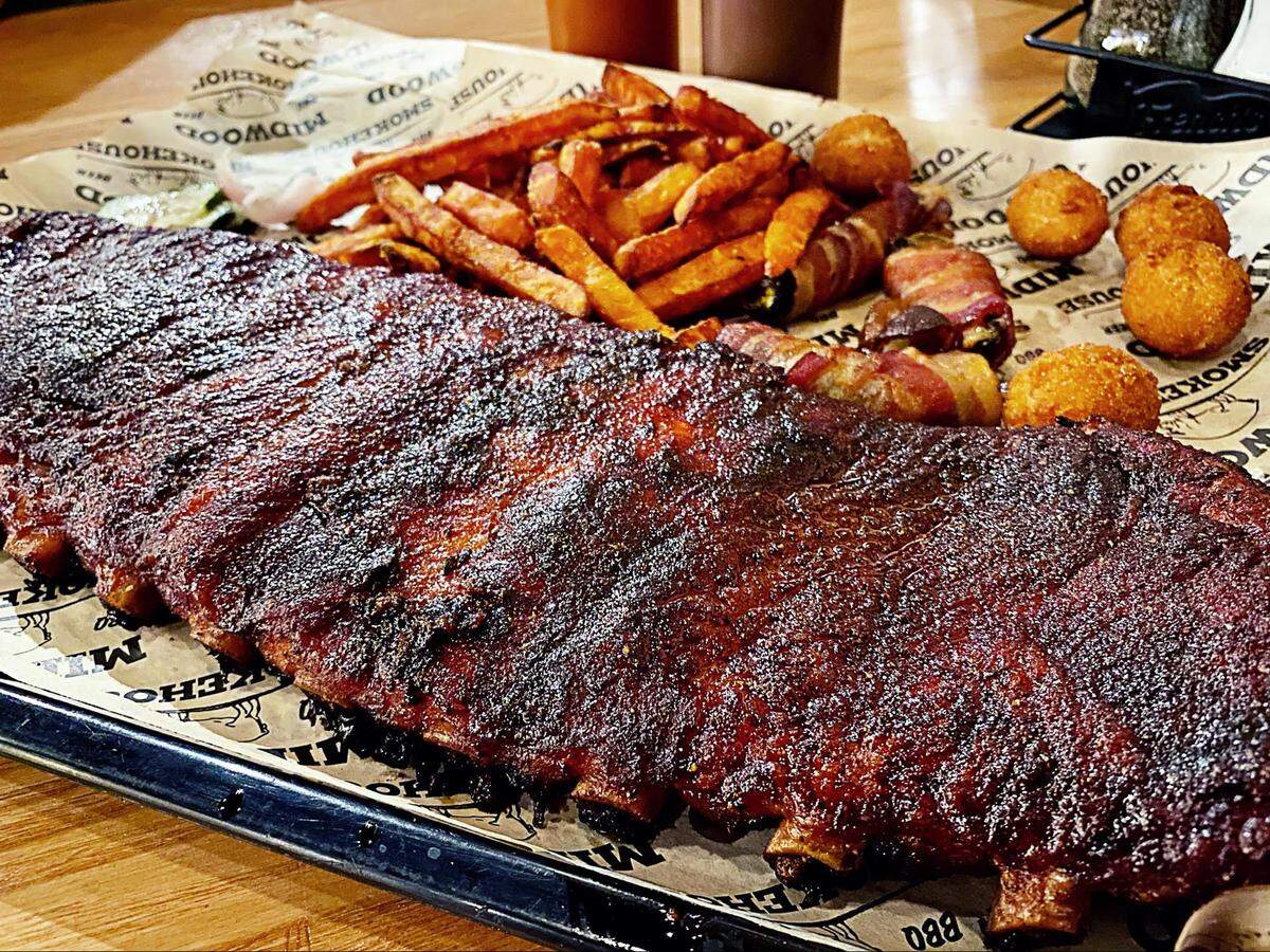 A whole rack of ribs with two side items plus hushpuppies at Midwood Smokehouse is $25.