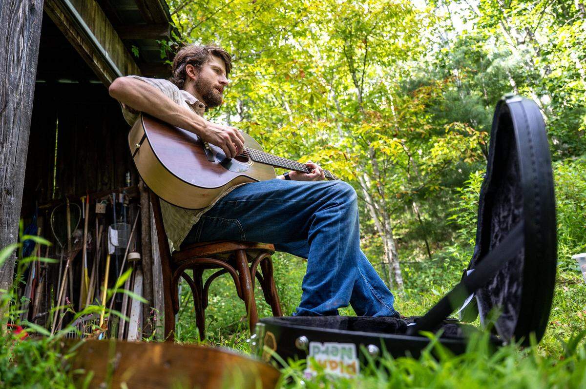  William Ritter, musician and seed saver, performs an original song about seeds and their associated histories at his family’s farm in Bakersville on Aug. 10.  