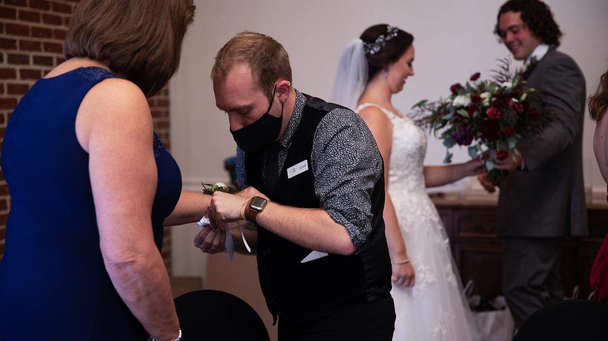 Trent Crumpler (middle) ties a corsage for the mother of the bride before the wedding of Cassidy Taylor and Gregory Hoffmann at the Sheraton Raleigh Hotel on Oct. 8.