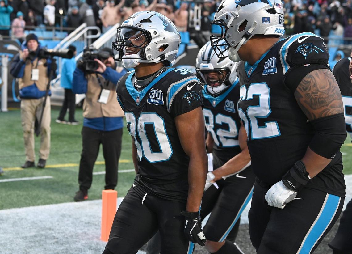 Carolina Panthers running back Chuba Hubbard, center, is congratulated by his teammates after scoring the game winning touchdown against the Arizona Cardinals at Bank of America Stadium in Charlotte, NC on Sunday, December 22, 2024. The Panthers defeated the Cardinals in overtime 36-30.
