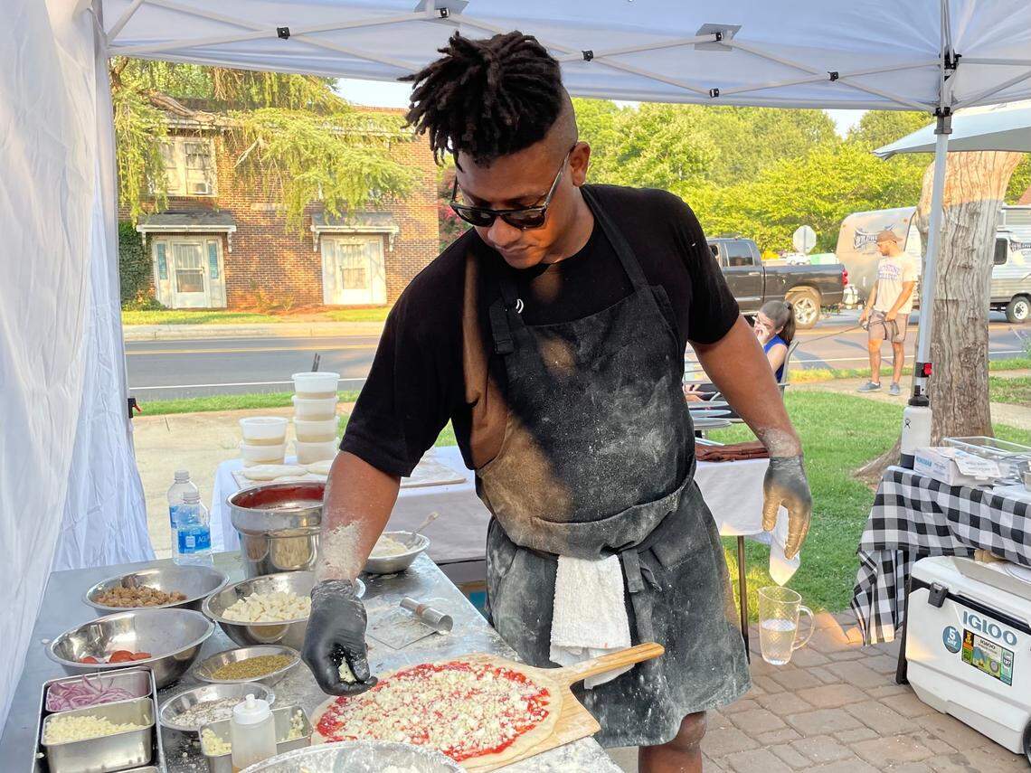 Kerrel Thompson prepares a pizza for the oven.