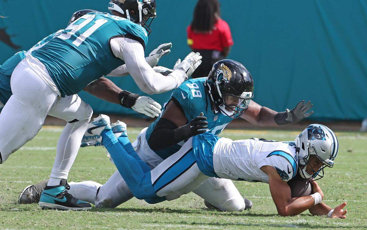 Carolina Panthers quarterback Bryce Young, right, is sacked by Jacksonville Jaguars defensive end Dawuane Smoot, center, during action on Sunday, September 7, 2025 at Everbank Stadium in Jacksonville, Florida. The Jaguars defeated the Panthers 26-10.