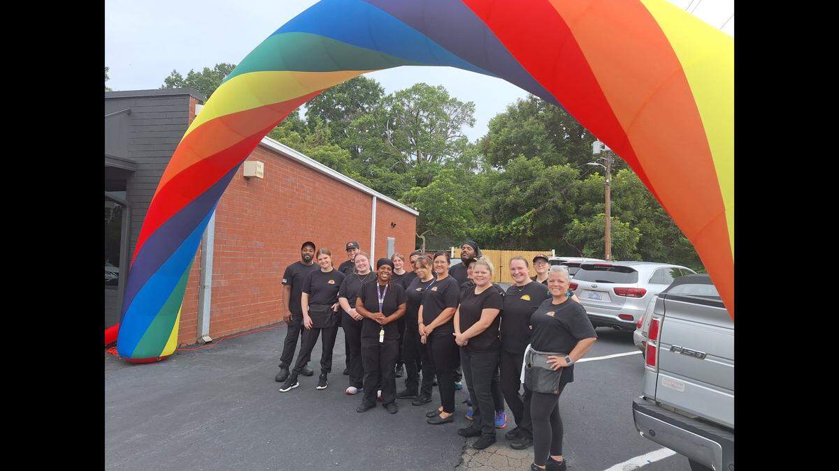 Employees pose under the giant inflatable rainbow outside Rise Cafe’s new Mooresville location on opening day, Friday, July 26, 2024.