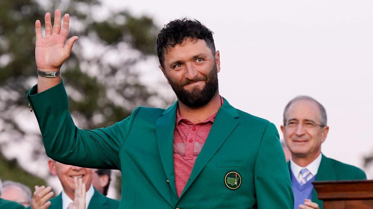 Jon Rahm waves to the crowd after donning his green jacket after winning The Masters golf tournament.