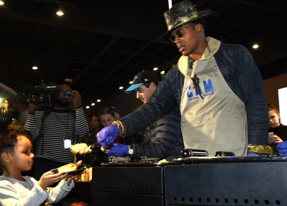 In this 2018 Charlotte Observer file photo, Cam Newton serves up some mac and cheese to a young guest at the 7th annual Cam’s Thanksgiving Jam.