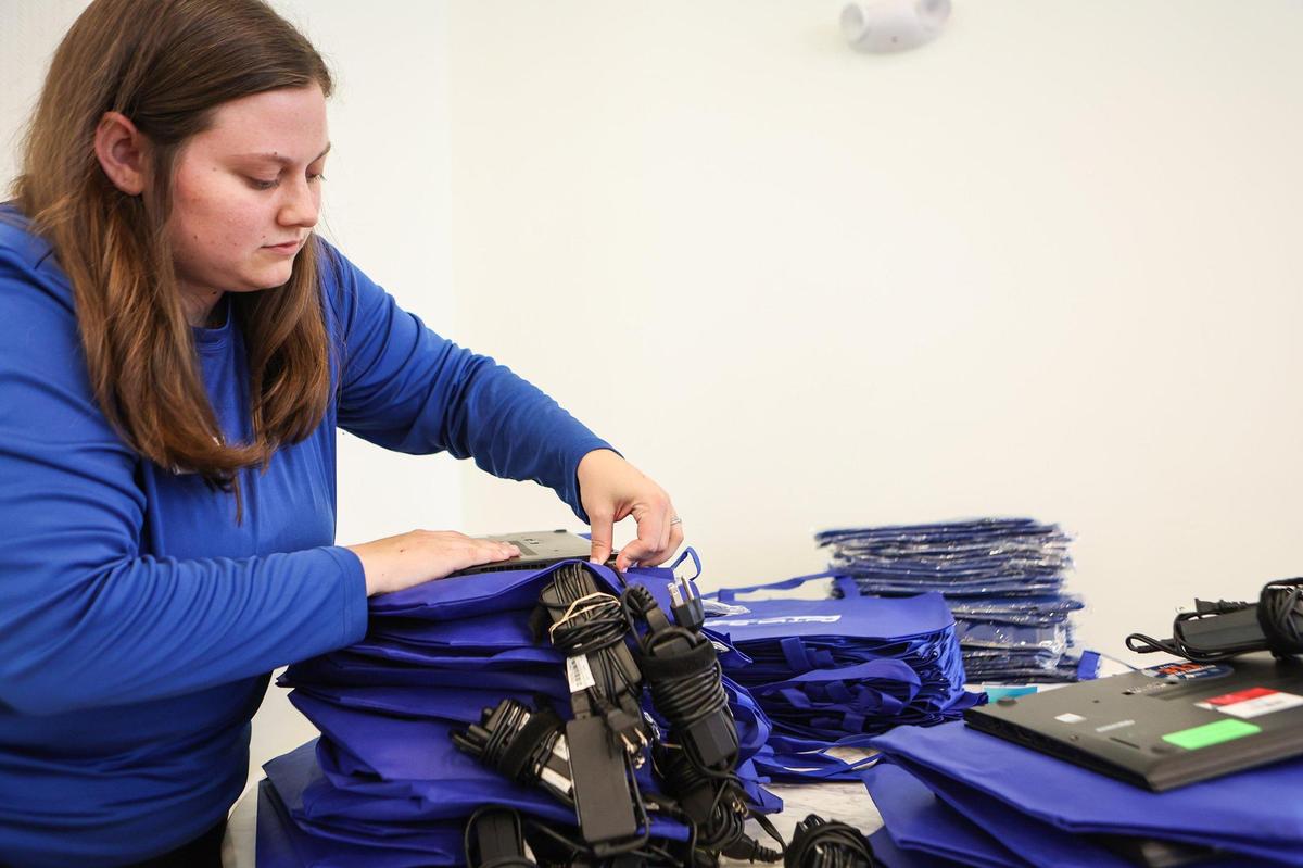 E2D employee Ashley Smith plugs a charging cord to a laptop so it is ready to be plugged in when the resident receives it during a kickoff event held by E2D, the Center for Digital Equity, LISC, and Barings at Evoke Living at Westerly Hills on Thursday, October 27, 2022. The event marks the beginning of a three-year initiative funded by Barings to increase digital equity in affordable housing communities across Charlotte that are part of the Charlotte Housing Opportunity Investment Fund (CHOIF)