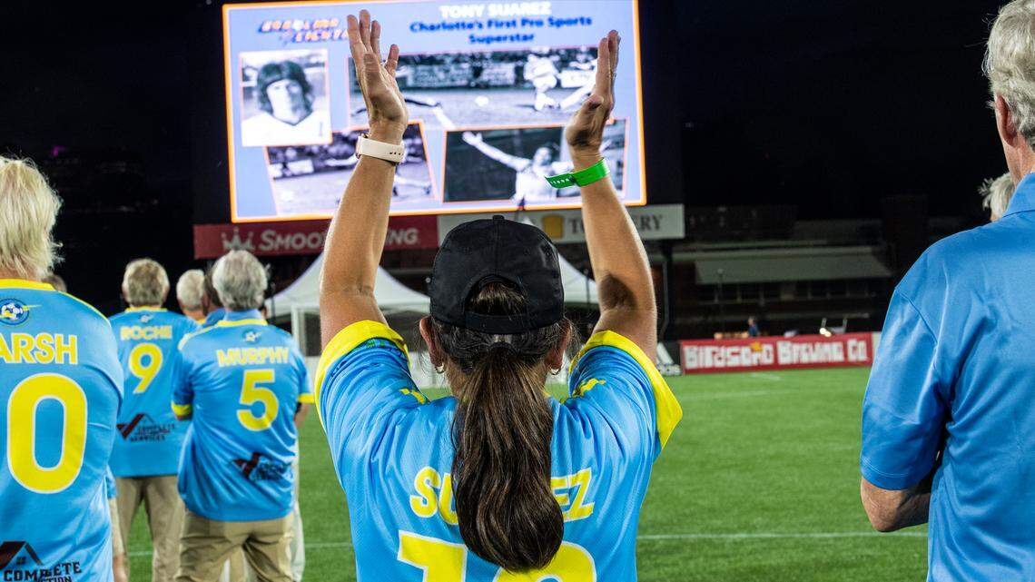 Ana Suarez Fleming, center, youngest sister of the late soccer player Tony Suarez, raises her arms to clap for a tribute on the big screen to her brother during a throwback night at a Charlotte Independence soccer game at American Legion Memorial Stadium on Saturday, September 18, 2021 in Charlotte, NC.