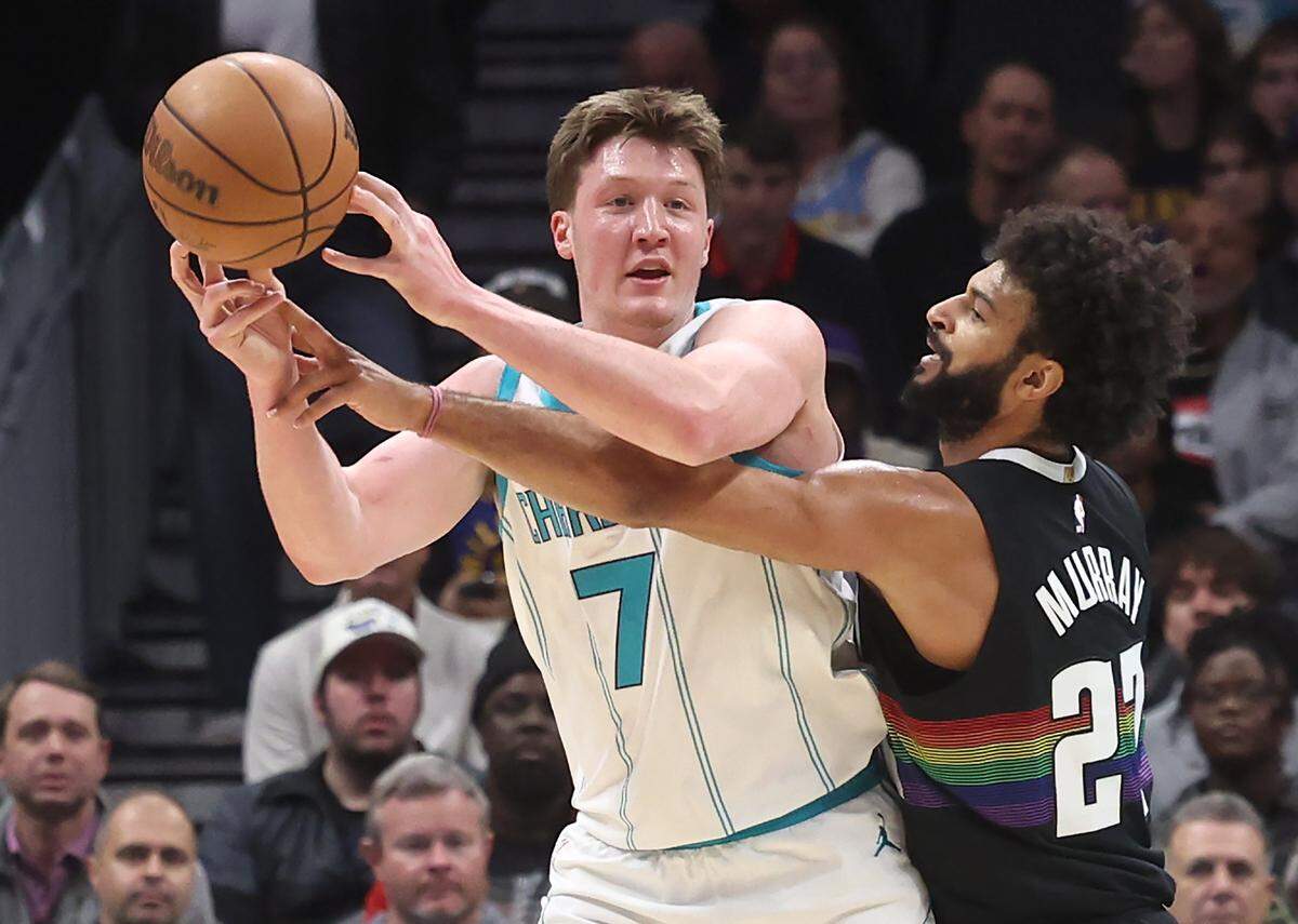 Charlotte Hornets forward Kon Knueppel, left, looks to pass as Denver Nuggets guard Jamal Murray applies defensive pressure during action at Spectrum Center in Charlotte, North Carolina, on Sunday, Dec. 7, 2025.