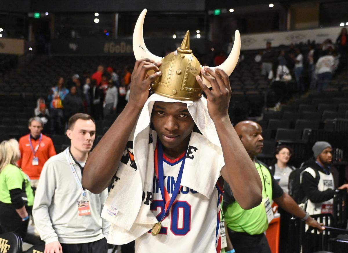 North Meck’s Exzavier Young adjusts a pair of a Viking helmet as he and his teammate celebrate their 57-47 victory over New Hanover in the NCHSAA 4A State Championship at Lawrence Joel Veterans Memorial Coliseum in Winston-Salem, NC on Saturday, March 16, 2024.