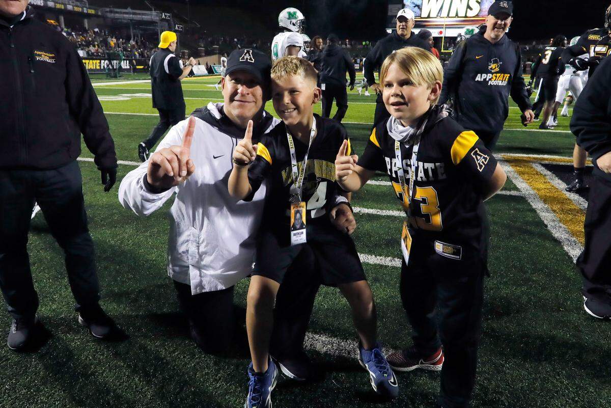 Appalachian State Mountaineers head coach Shawn Clark (left) with son Braxton and a friend after a 2021 game against the Marshall Thundering Herd at Kidd Brewer Stadium in Boone.