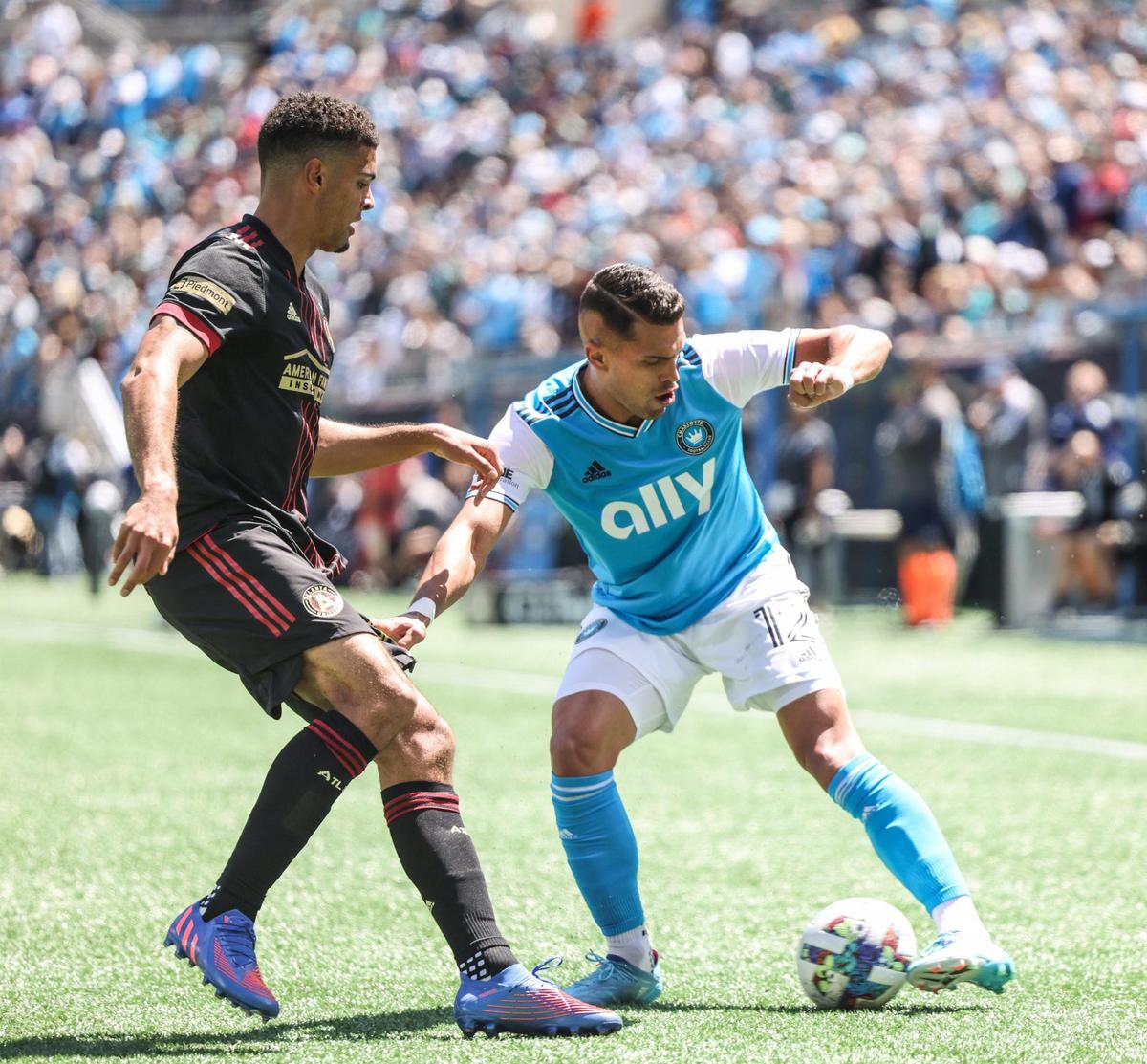 Charlotte FC forward Daniel Ríos, right, controls the ball beside Atlanta United defender Miles Robinson at the Bank of America Stadium in Charlotte, N.C., on Sunday, April 10, 2022.