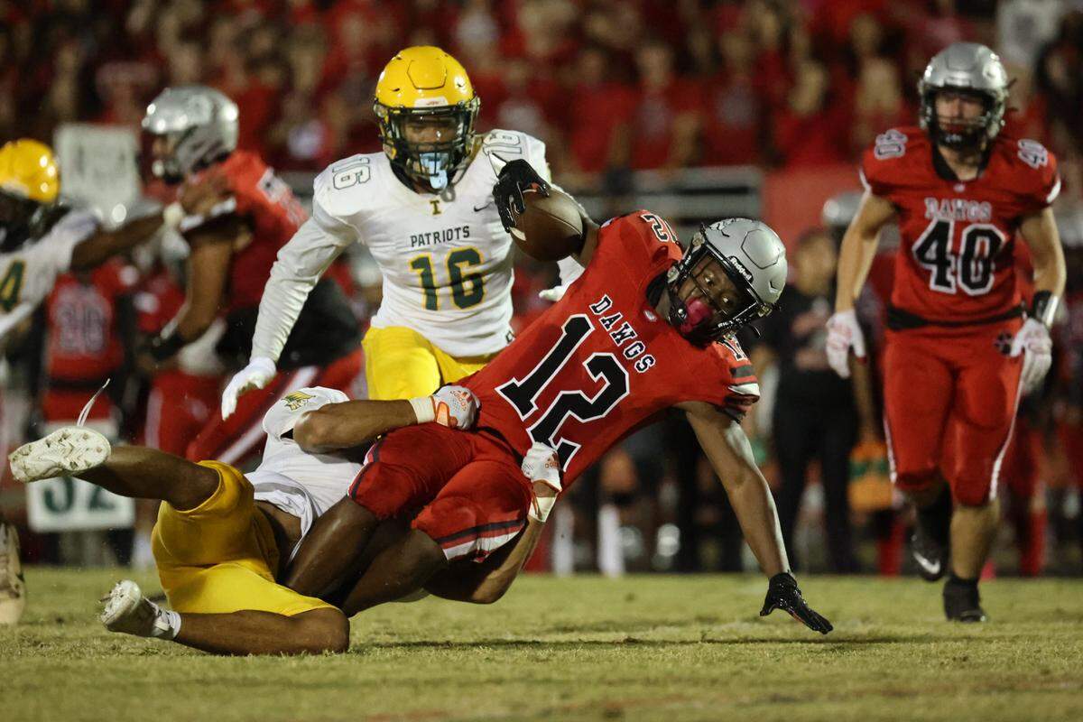 Butler junior Jayden Williams (12) is tackled by Independence sophomore Dallas Brannon (4) during the second quarter of the Southwestern 4A title game at Butler High School on October 27, 2023.