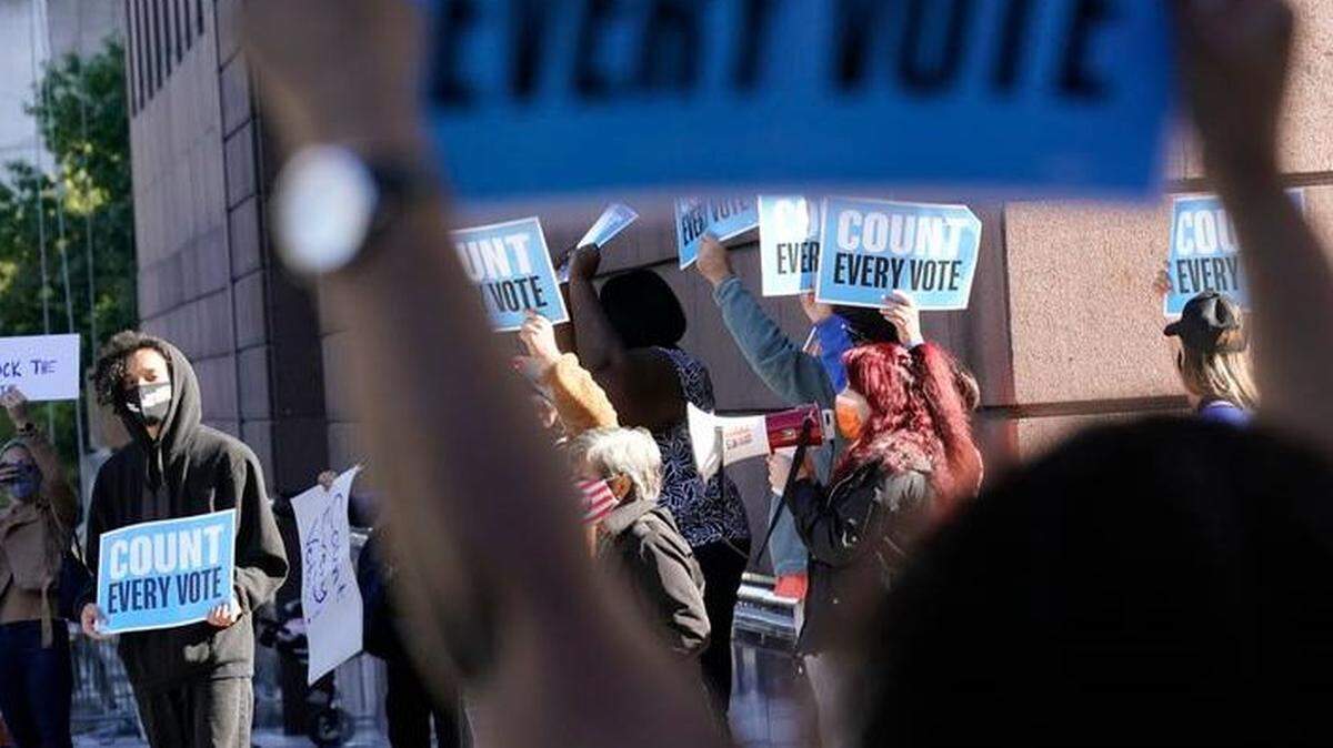 Demonstrators protest at the federal courthouse in Houston on Monday before a hearing involving drive-thru ballots cast there. The lawsuit was brought by conservative activists who’ve rallied against expanded voting access.  Similar lawsuits have popped up across the U.S.
