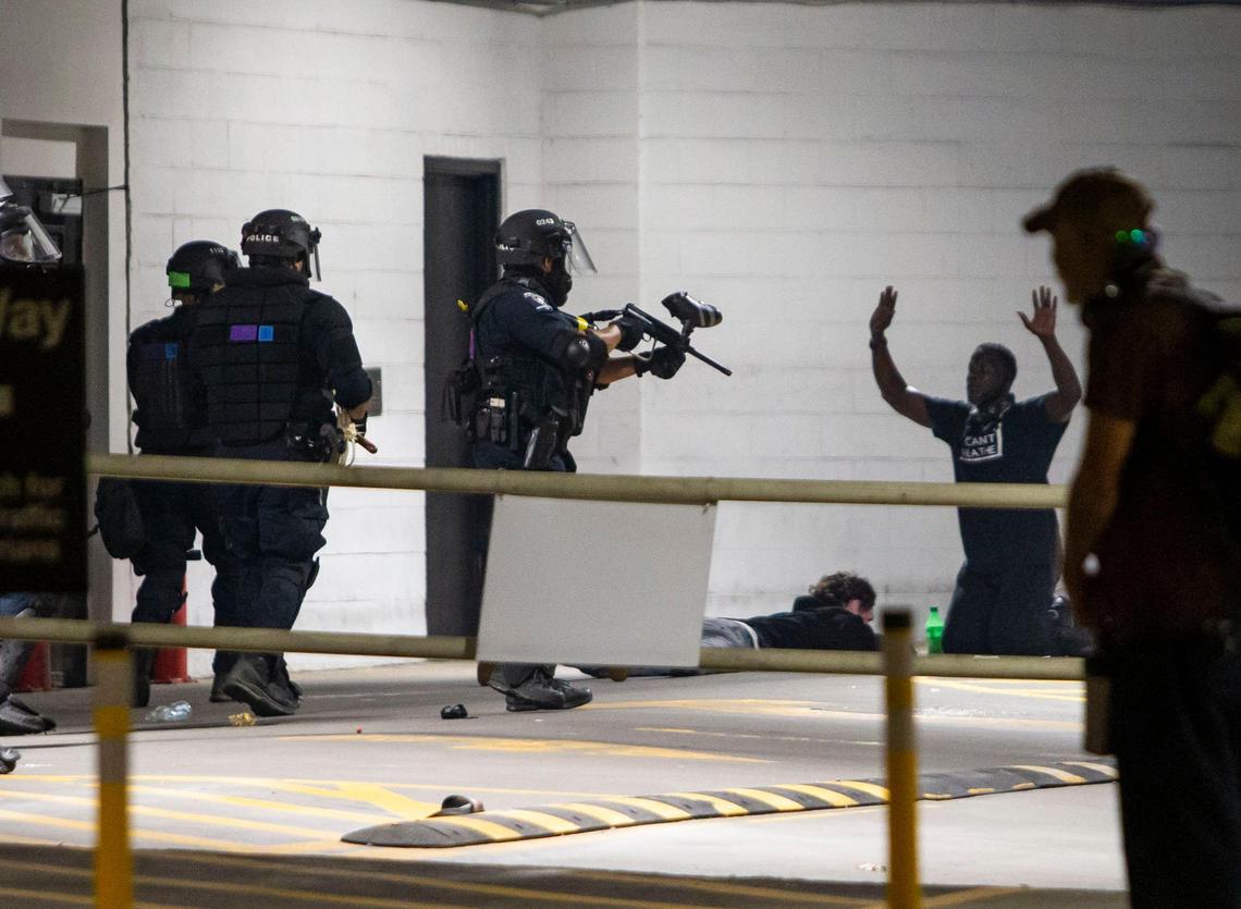 Police advance on two protesters after using tear gas inside the Omni Hotel parking garage in uptown Charlotte, NC on Tuesday, June 2, 2020. Thousands gathered for a peaceful protest during the day until a group of nearly 300 continued to march through the streets of Charlotte.