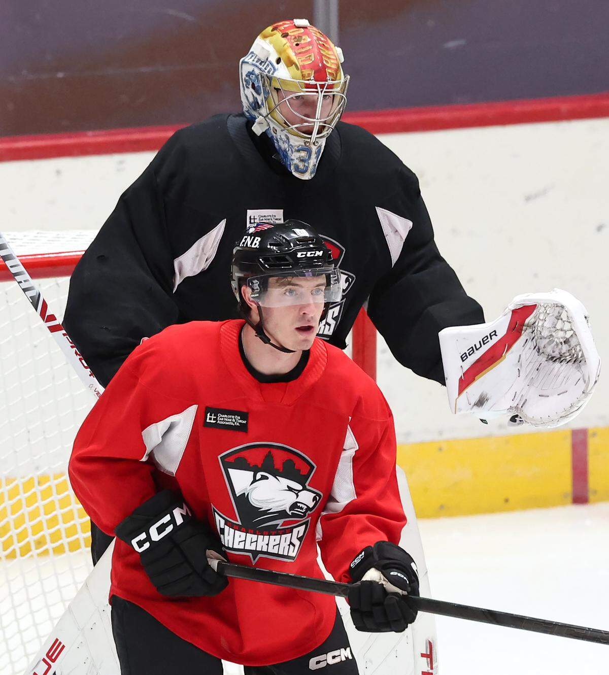 Charlotte Checkers goalie Cooper Black towers over teammate Ben Steeves during practice at BoJangles Coliseum in Charlotte, NC on Thursday, October 9, 2025.