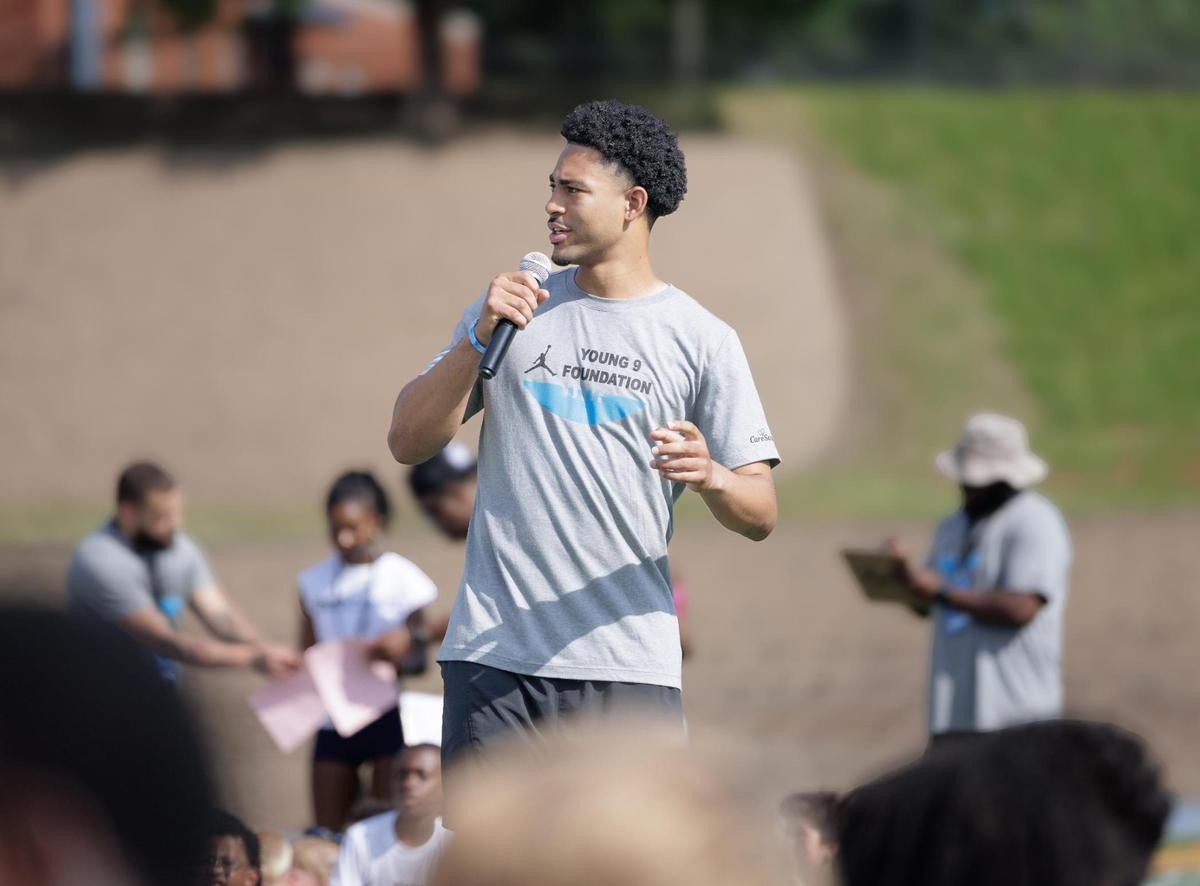 Carolina Panther quarterback Bryce Young (center) gives camp opening comments to the over 300 youth football campers hosted at Johnson C. Smith University Saturday, June 7, 2025.