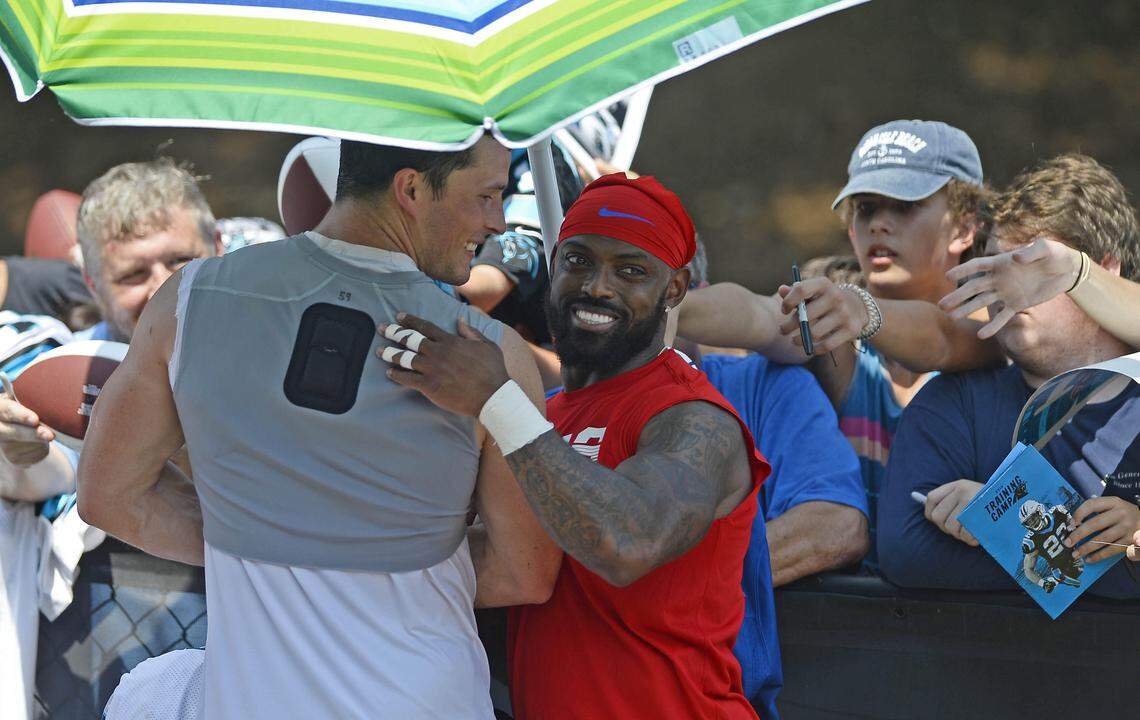 Buffalo cornerback Captain Munnerlyn (in red) talks with Carolina Panthers middle linebacker Luke Kuechly -- his former teammate -- as they sign autographs Tuesday.
