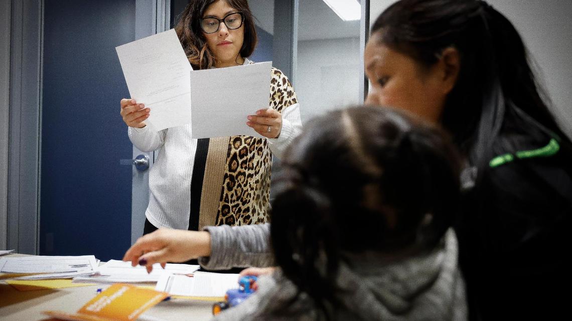 Staff attorney Kiara Vega, of Charlotte, N.C., left, works with a mother and daughter from Honduras who are seeking asylum at the Charlotte Center for Legal Advocacy in Charlotte, Saturday, March 26, 2022.