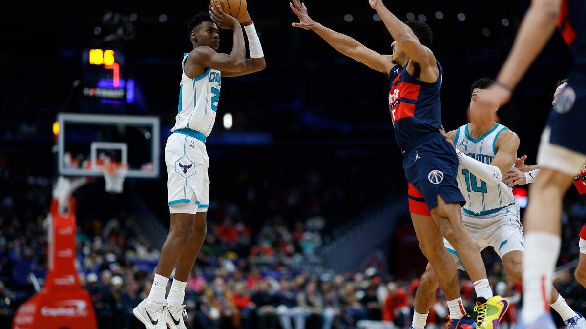 Dec 26, 2024; Washington, District of Columbia, USA; Charlotte Hornets forward Brandon Miller (24) shoots the ball aa Washington Wizards guard Malcolm Brogdon (15) defends in the second quarter at Capital One Arena.
