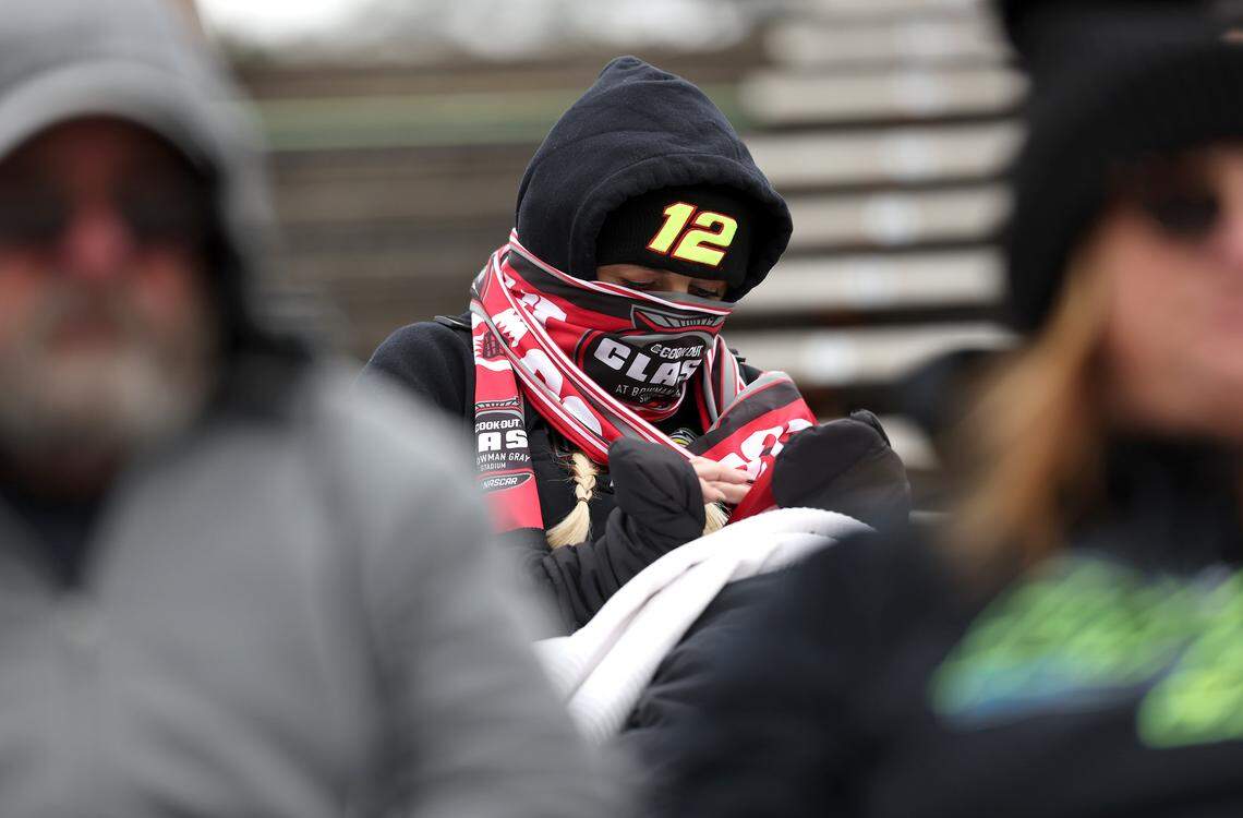 A NASCAR fan sits bundled up in the stands as NASCAR Cup Series drivers practice at Bowman Gray Stadium in Winston-Salem on Wednesday, Feb. 4, 2026. The stadium is hosting the Cookout Clash.