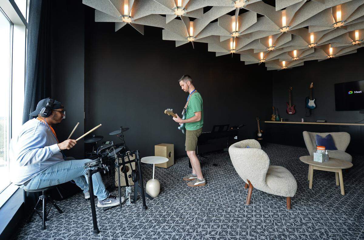 Credit Karma employees Ahmad Waller, left and David Bowen, right, practice in the music room at Credit Karma’s new office in Ballantyne.
