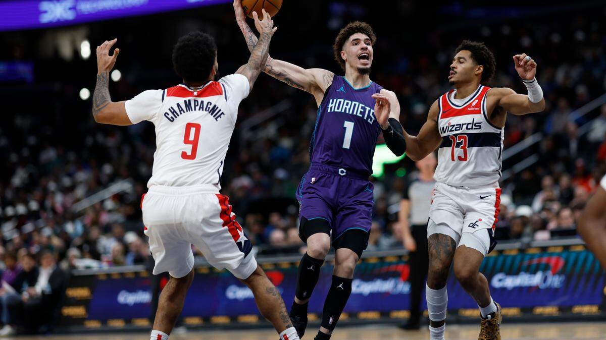Charlotte Hornets guard LaMelo Ball (1) drives to the basket as Washington Wizards forward Justin Champagnie (9) and Wizards guard Jordan Poole (13) defend in the second quarter at Capital One Arena.
