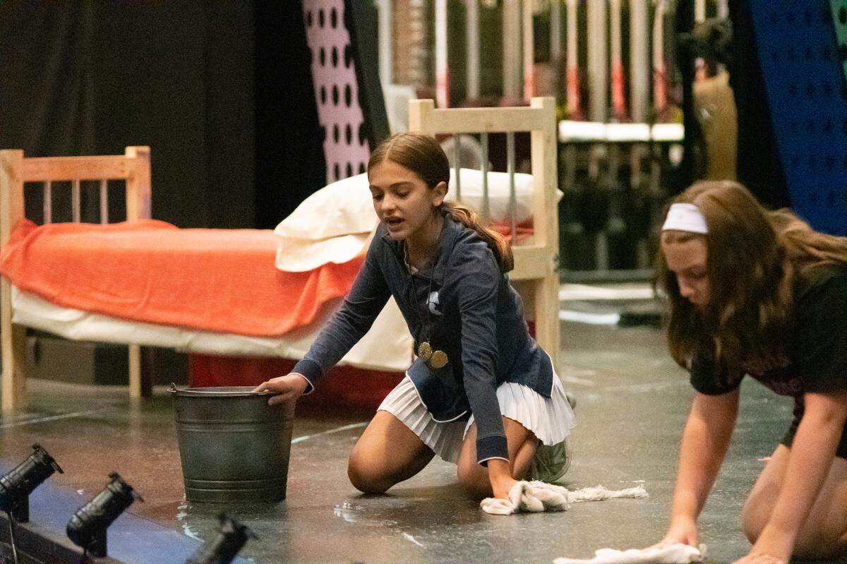 Emma Griggs, at the bucket, as one of the girls who alternates as Annie, in rehearsal for “It’s the Hard Knock Life” of “Annie” with fellow orphan Kennedy Bishop.
