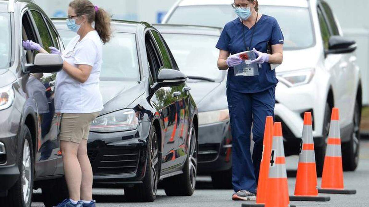 Novant Health personnel attend to people receiving a COVID-19 tests at a Charlotte testing site on June 15. COVID cases and unemployment are rising in the state, but the N.C. legislature ended its short session last week without expanding Medicaid.