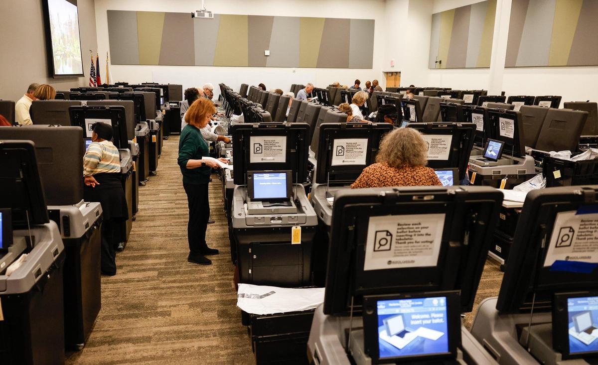 Volunteers feed ballots into ballot machines as Mecklenburg officials hold a recount in NC Supreme Court race and two Mecklenburg County legislative races at the Valerie C. Woodard Community Resource Center in Charlotte, NC on Thursday, November 21, 2024.