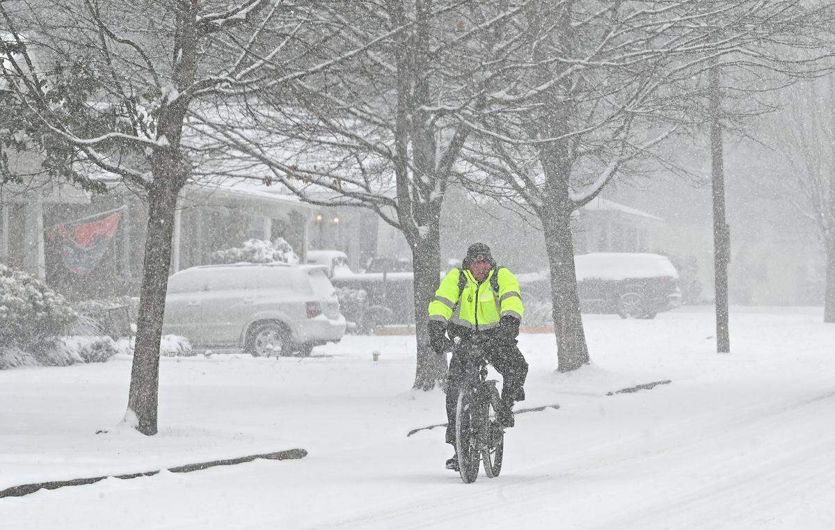 A bicyclist rides along Commonwealth Ave. in the falling snow in Charlotte, NC on Saturday, January 31, 2026.