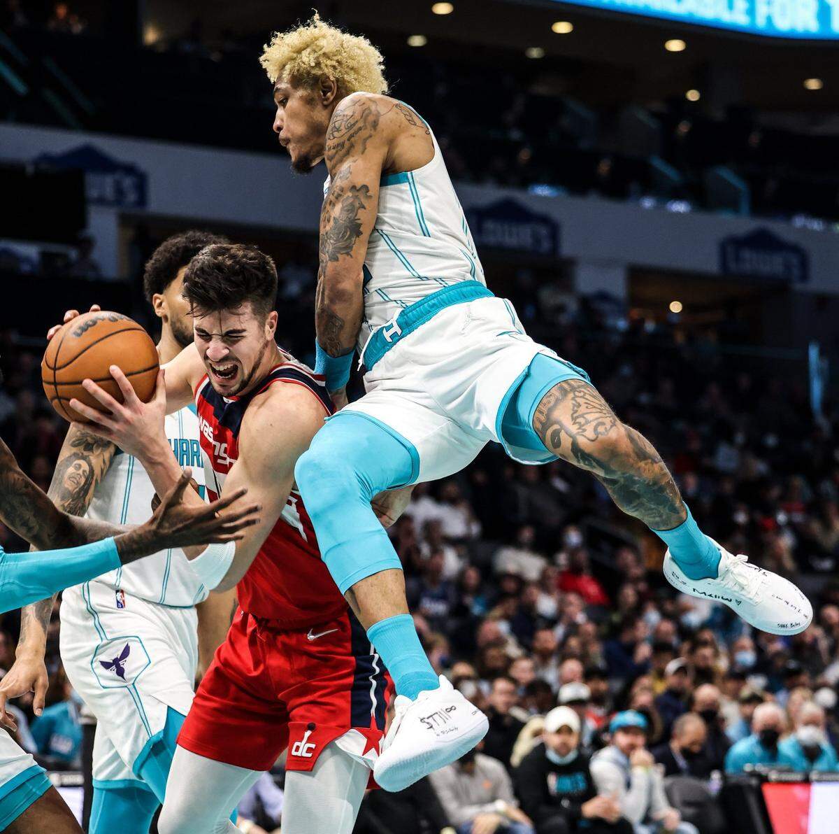 Washington Wizards Deni Avdija, left, collides with Charlotte Hornets Kelly Oubre Jr.at the Spectrum Center in Charlotte, N.C., on Wednesday, November 17, 2021.
