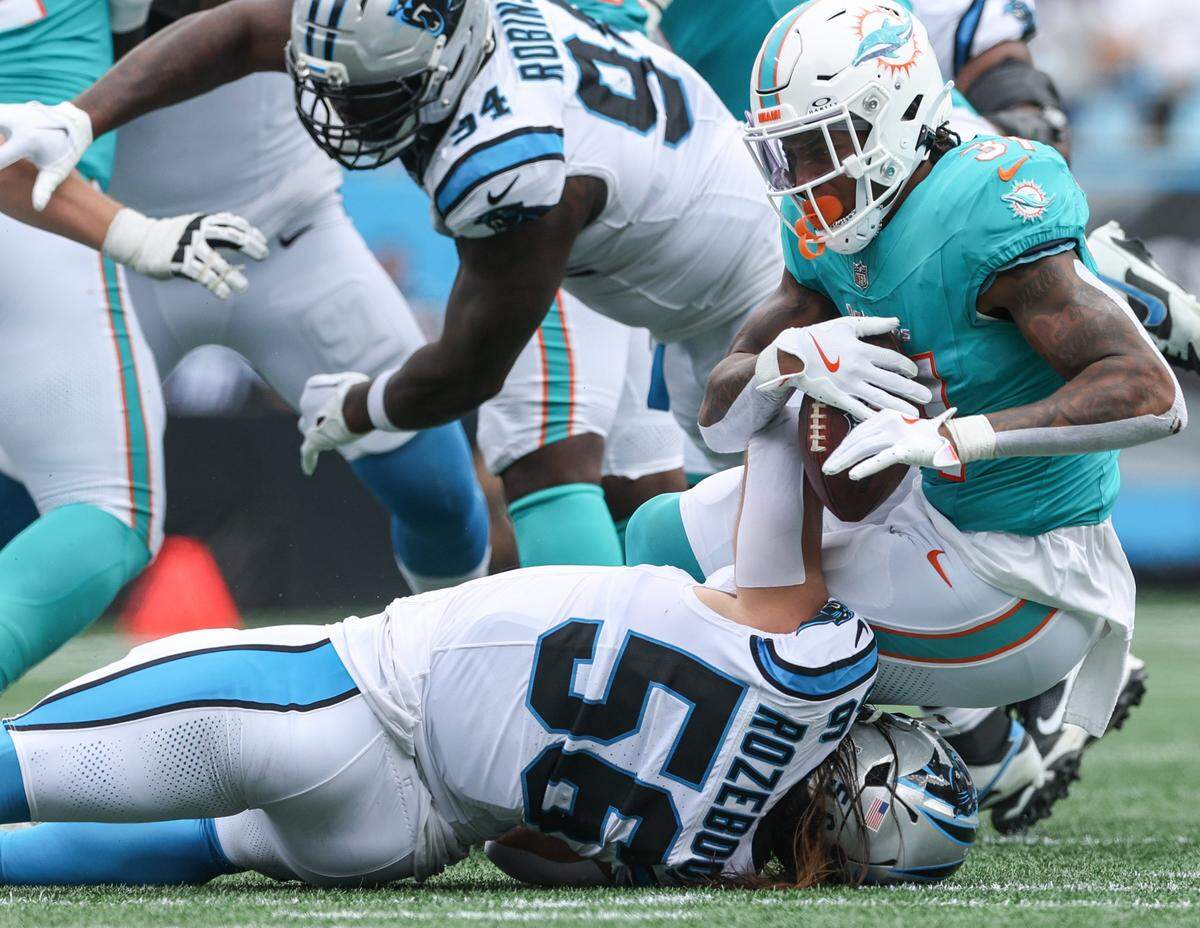 As soon as Dolphins runningback Ollie Gordon II gets the ball, he is tackled by Panthers linebacker Christian Rozeboom during the game against the Dolphins at Bank of America Stadium in Charlotte, NC on Sunday, October 5, 2025.