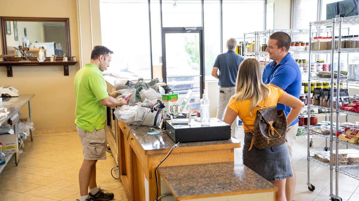 Customers shop and chat inside Agora Greek Market.