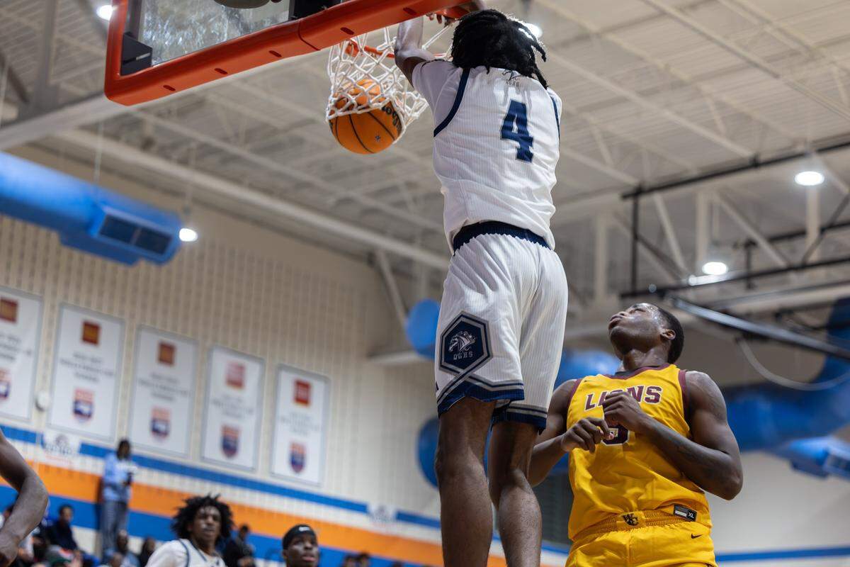 Queen’s Grant Stallions player Mekhi Allen, left, makes a dunk past the West Charlotte Lions’ Jkhai Wade during the Mike Gminski Classic at Marvin Ridge High School in Waxhaw, North Carolina, on Monday, Dec. 29, 2025.