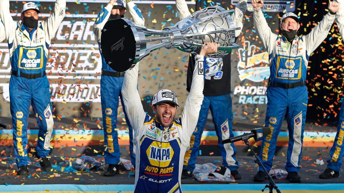 Chase Elliott holds up the season championship trophy as he celebrates with his race crew in Victory Lane after winning a NASCAR Cup Series auto race at Phoenix Raceway, Sunday, Nov. 8, 2020, in Avondale, Ariz. (AP Photo/Ralph Freso)