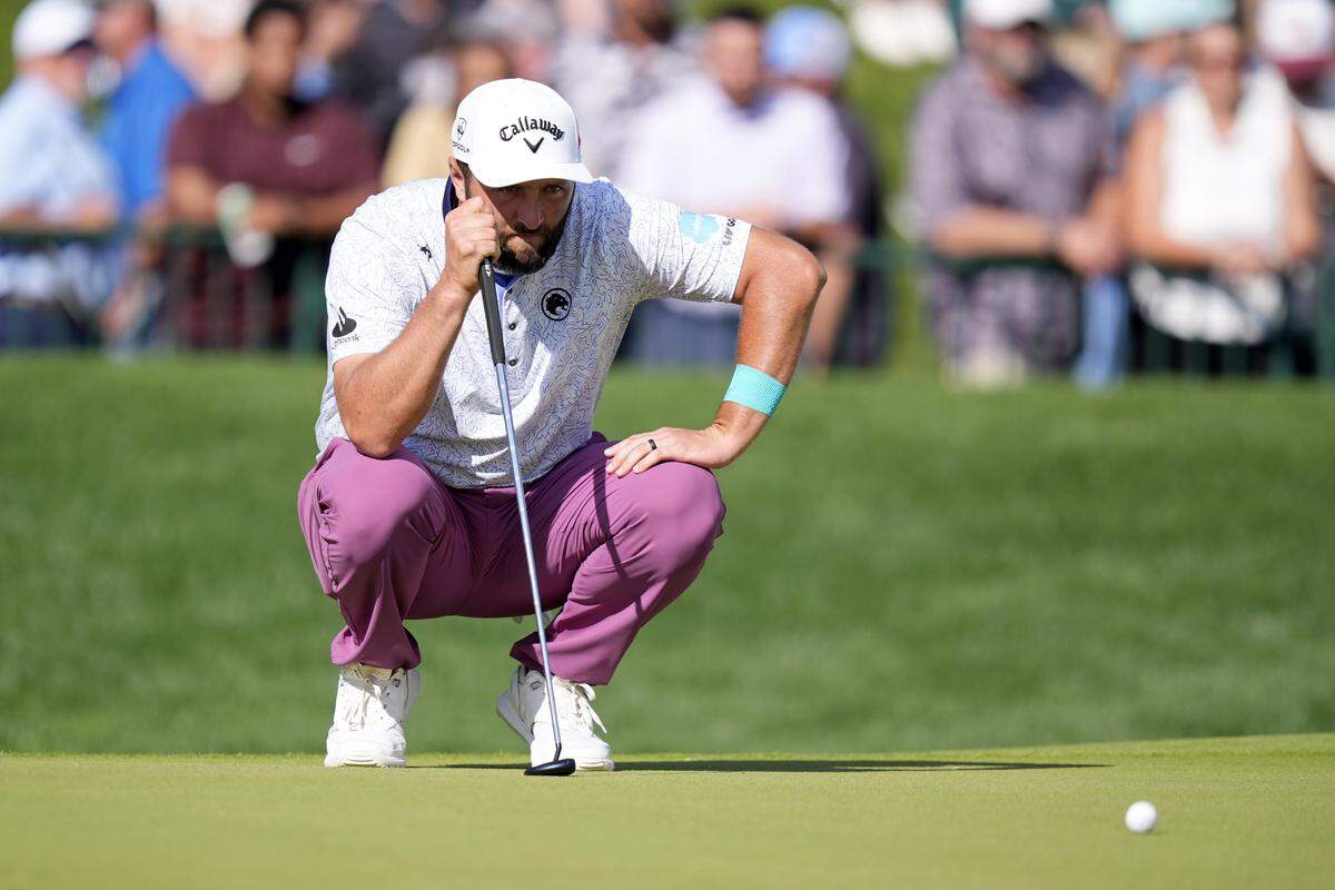 Jon Rahm lines up a putt on the 18th green during the third round of the PGA Championship golf tournament at Quail Hollow.