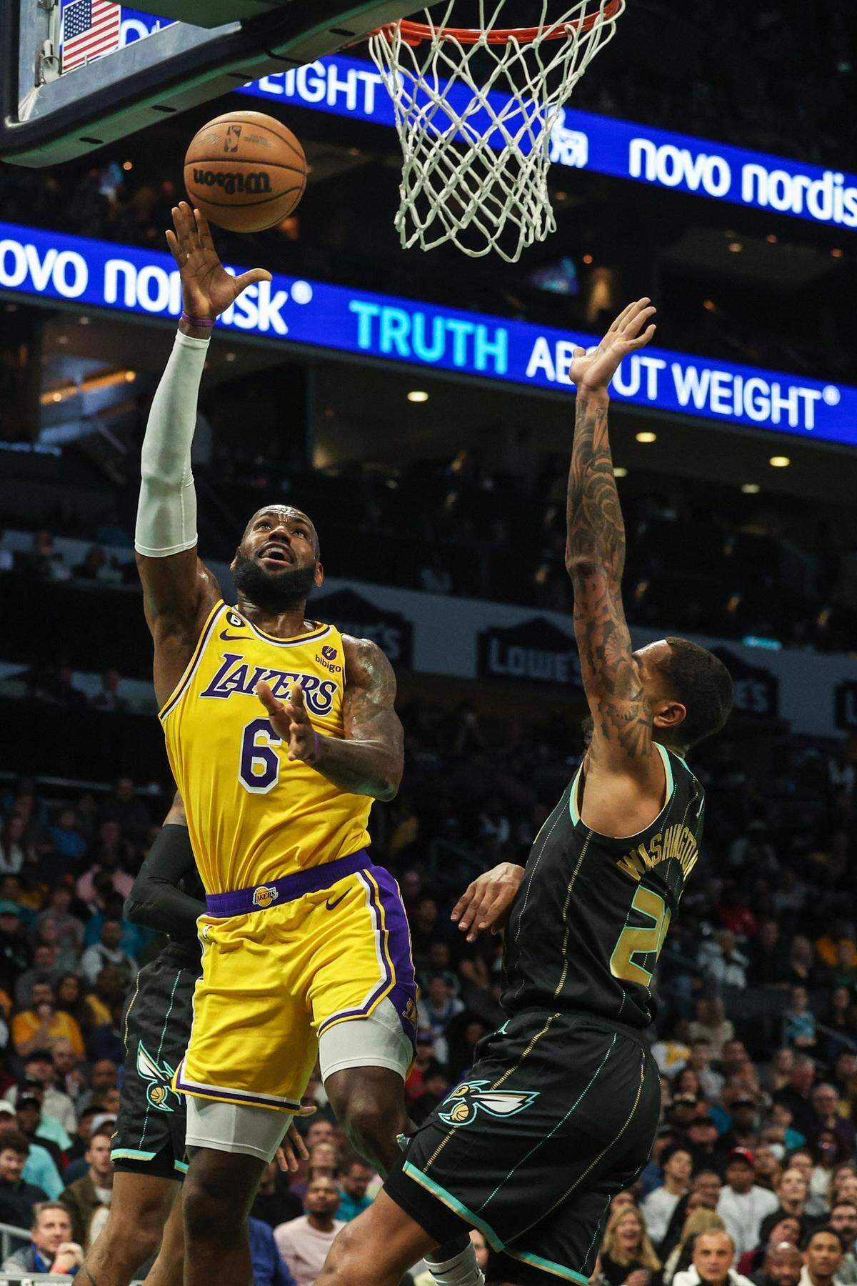 Los Angeles Lakers guard LeBron James, left, shoots over Hornets guard PJ Washington during a game at Spectrum Center on Monday, January 2, 2023. The Lakers won, 121-115, as James scored 43 points.