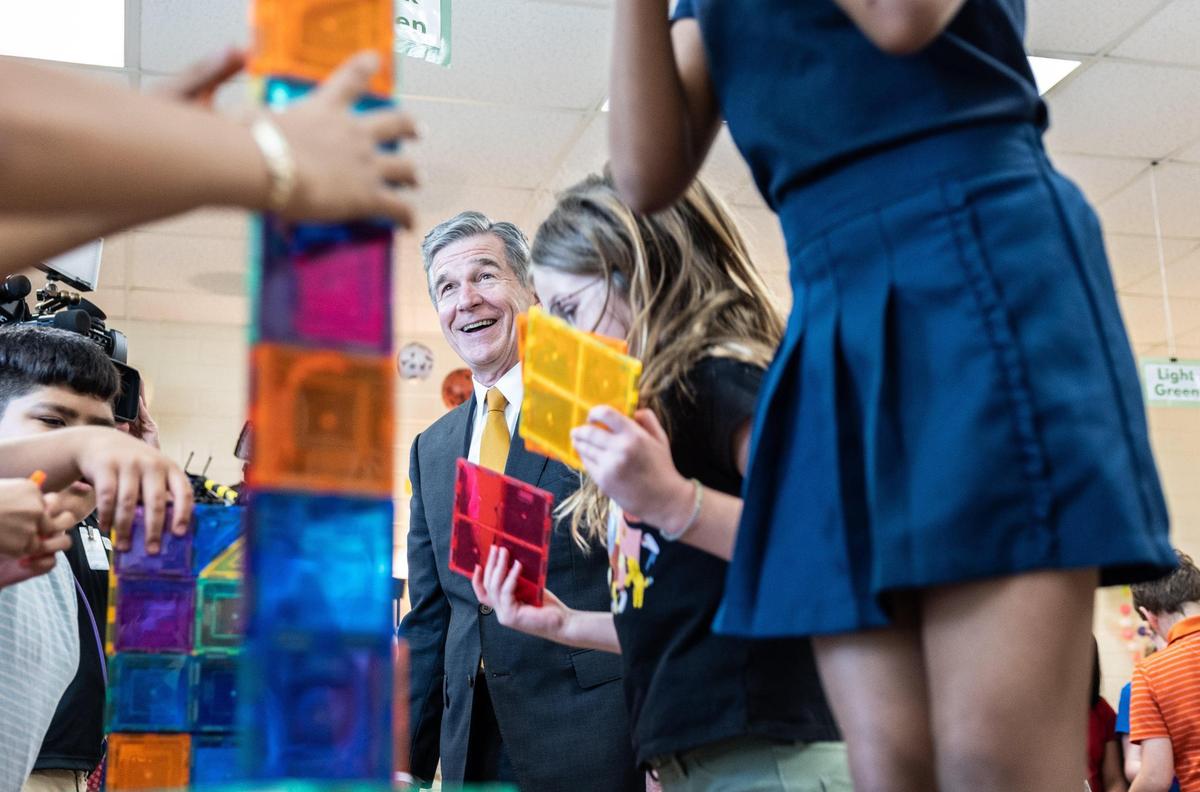 Gov. Roy Cooper watches as students at Huntingtowne Farms build towers out of materials provided by their teacher.