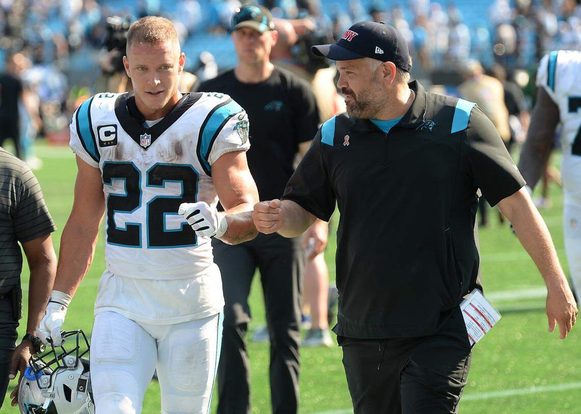 Carolina Panthers running back Christian McCaffrey, left and head coach Matt Rhule, right, bump fists in 2021. If McCaffrey stays healthy this season, Carolina will have a far better chance at reaching the team’s goals.