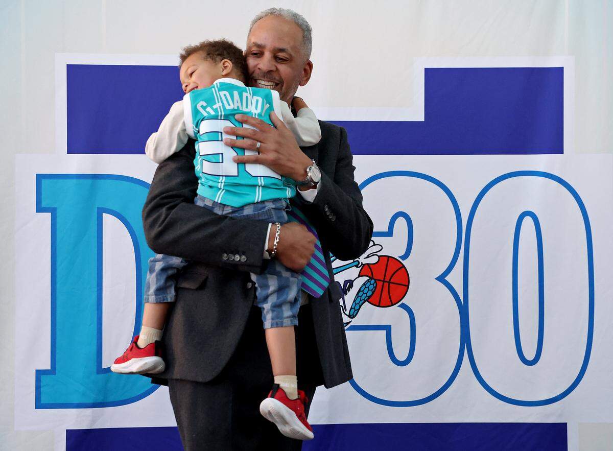 Former Charlotte Hornets star Dell Curry hugs his grandson, Cruz Curry, during a Thursday reception at Spectrum Center.
