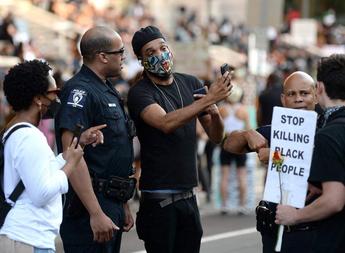 A demonstrator, right, speaks with a CMPD officer outside the Charlotte-Mecklenburg Government Center on Tuesday, June 2, 2020. Demonstrators joined together at the Charlotte- Mecklenburg Government Center in protest of the killing of George Floyd and other victims of police officers around the country