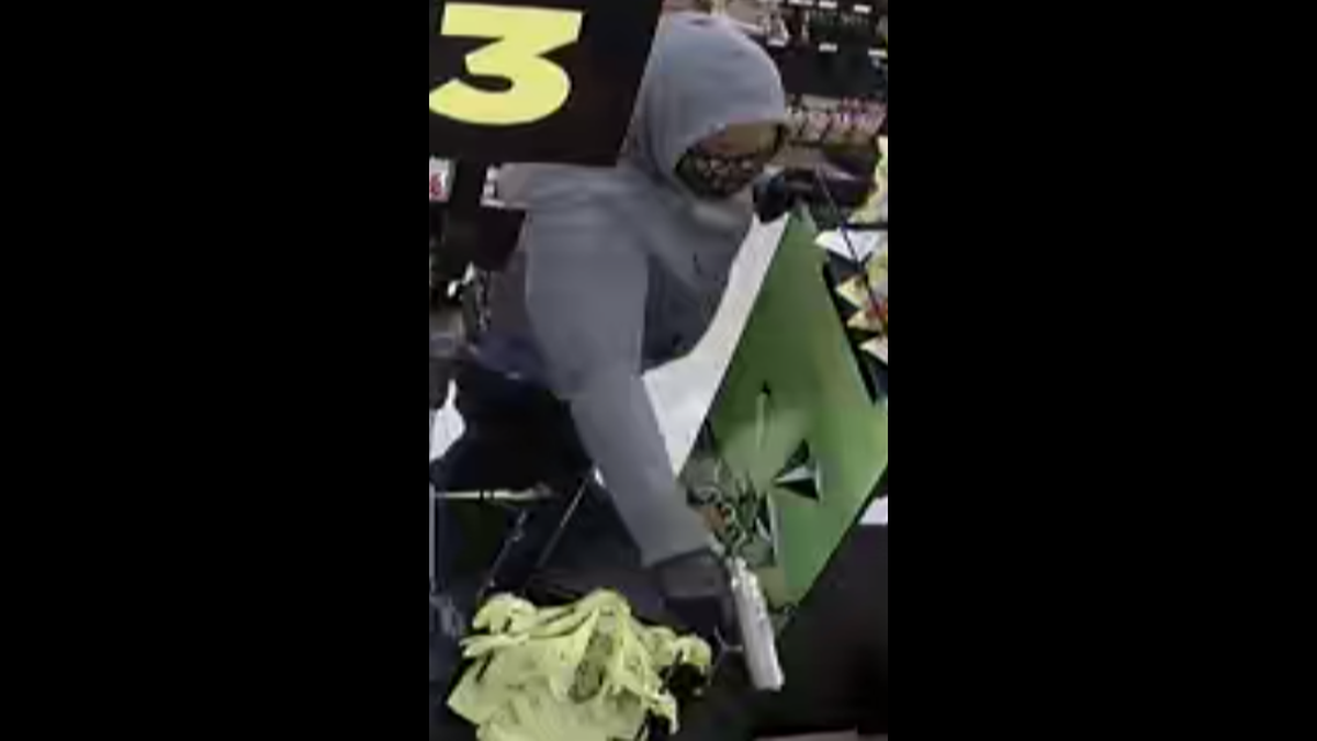A woman wearing a Louis Vuitton face mask is seen on security video robbing and shooting a gun inside a Dollar General on South Boulevard on Sunday, July 24. 