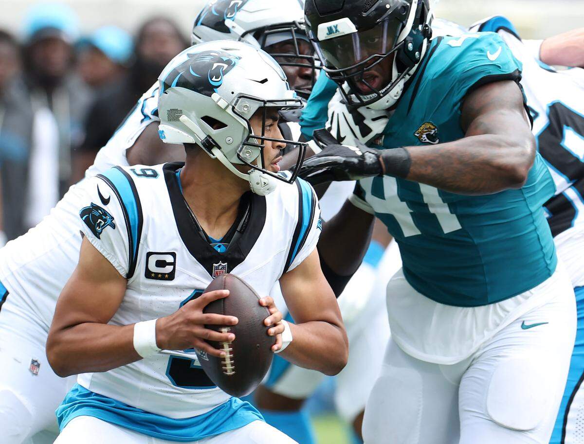 Carolina Panthers quarterback Bryce Young, left, stands in the pocket as Jacksonville Jaguars defensive end Josh Hines-Allen, right, rushes into the pocket during action on Sunday, September 7, 2025, at Everbank Stadium in Jacksonville, Florida. The Jaguars defeated the Panthers 26-10.