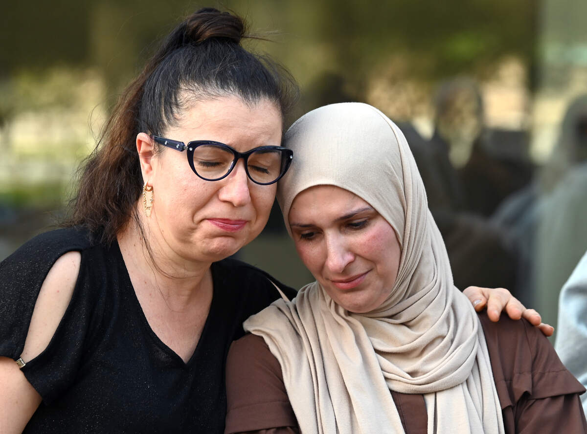 Anna Kirakozova, left, comforts the mother of the 15-year-old female Ardrey Kell High student who was assaulted on March 7. The family held a press conference on Friday asking the school to release a surveillance video.