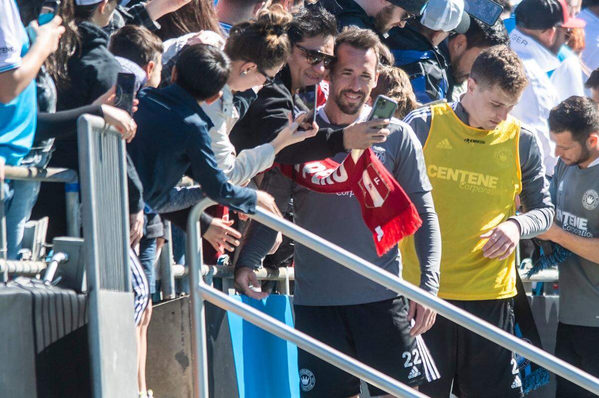Charlotte FC’s Christian Fuchs (fourth from left) poses for a selfie with a fan after an open training session at Bank of America Stadium in February.