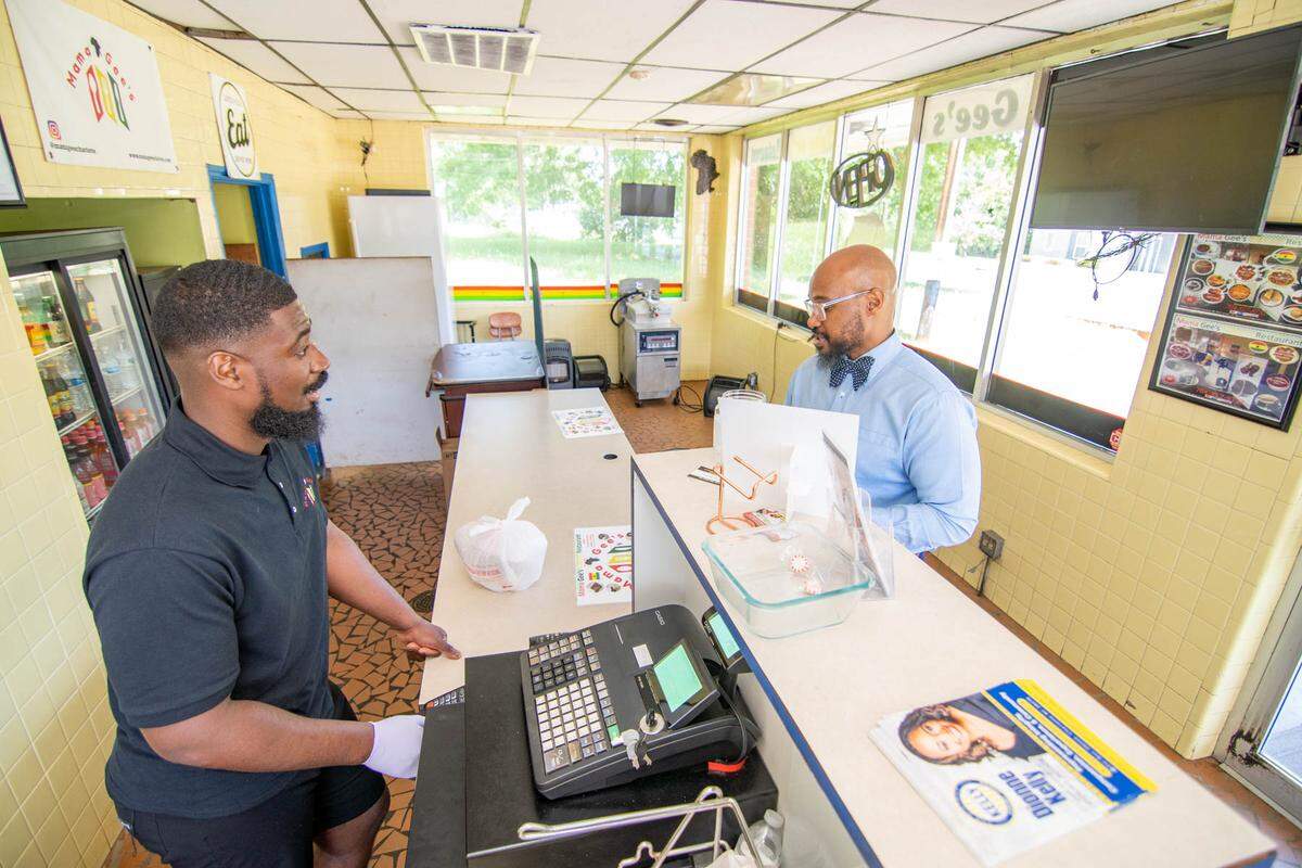 Kobbi Bonsu checks out a customer at Mama Gee’s restaurant.