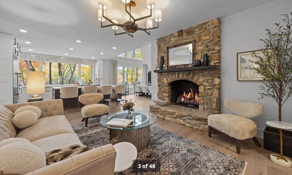 The first-floor open floor plan includes “walls of windows with unobstructed water views,” a great room with 16-foot vaulted ceiling, a stone fireplace and a beamed ceiling, according to the property listing.