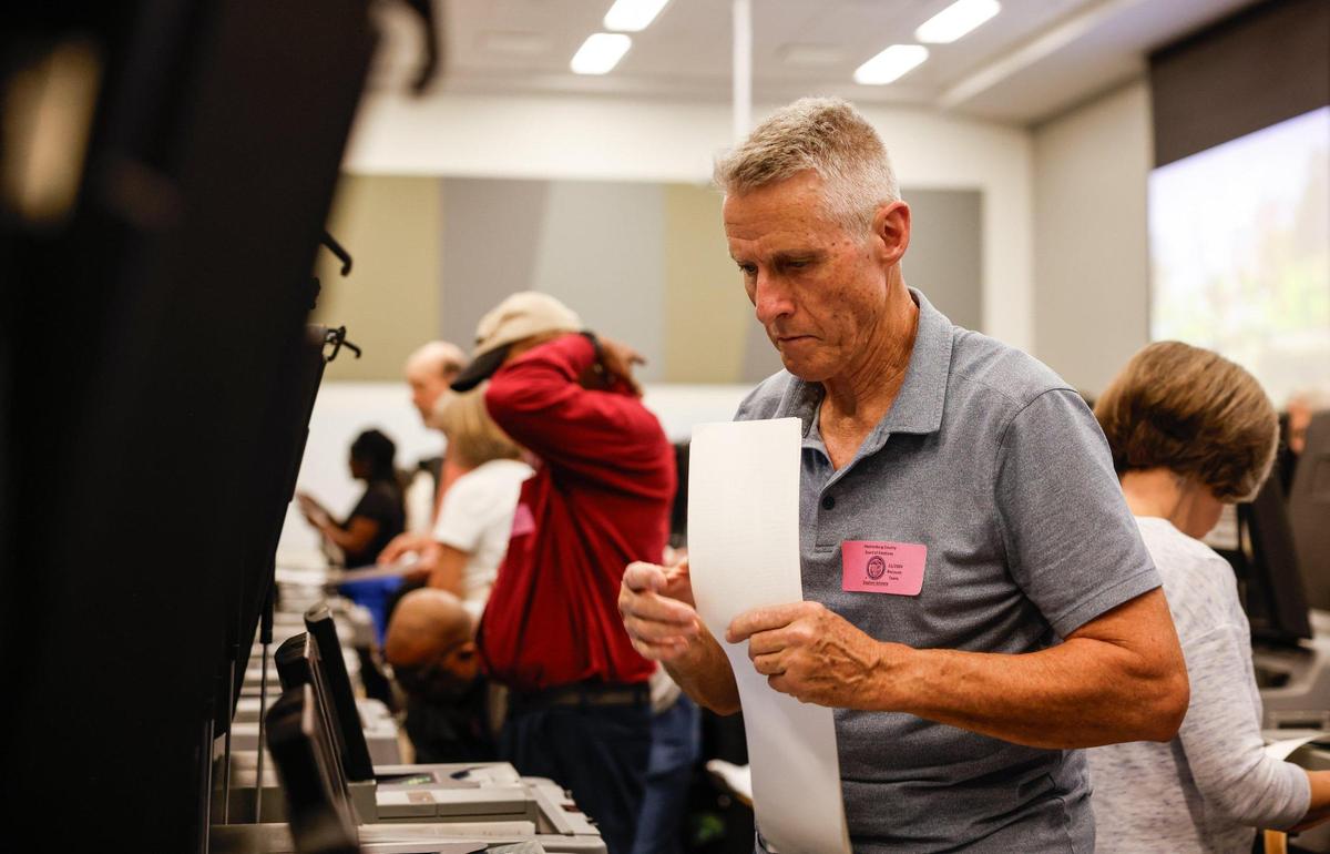 Recount team volunteer Stephen Schmitt assists Mecklenburg officials as they hold a recount.
